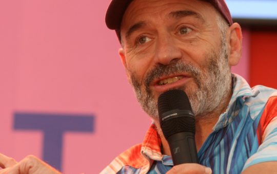 Professor Richard Betts speaking into a microphone Glastonbury