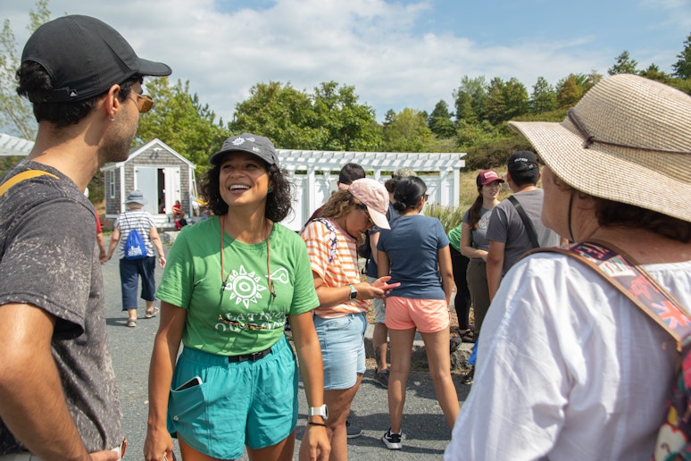 A group of people stand around, talking and smiling