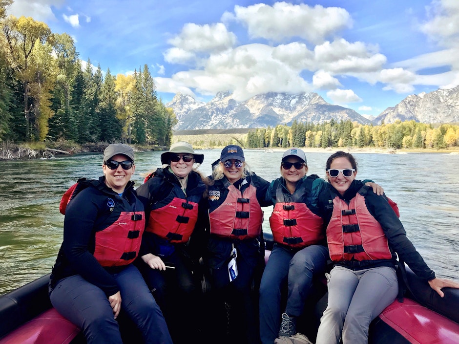 A group of people pose for a photo in the back of a boat