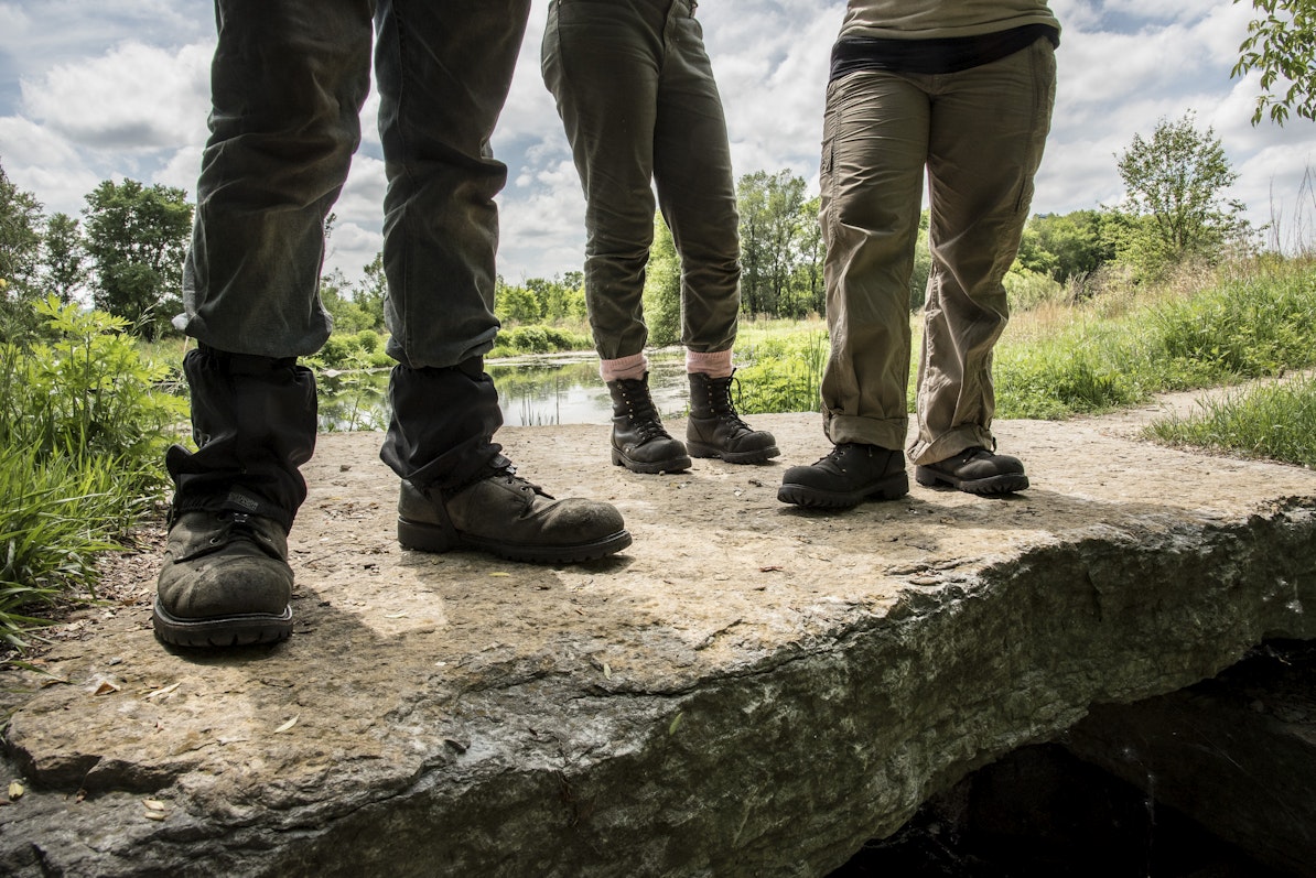 Three people stand on a rock