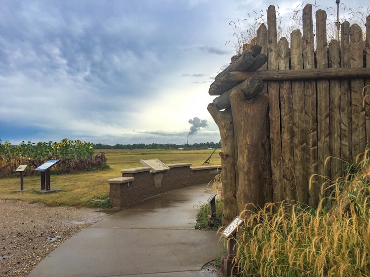 Sidewalk leading around an earthlodge on a sunny day