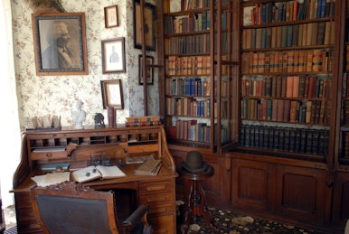 Desk and library shelves in a dark study