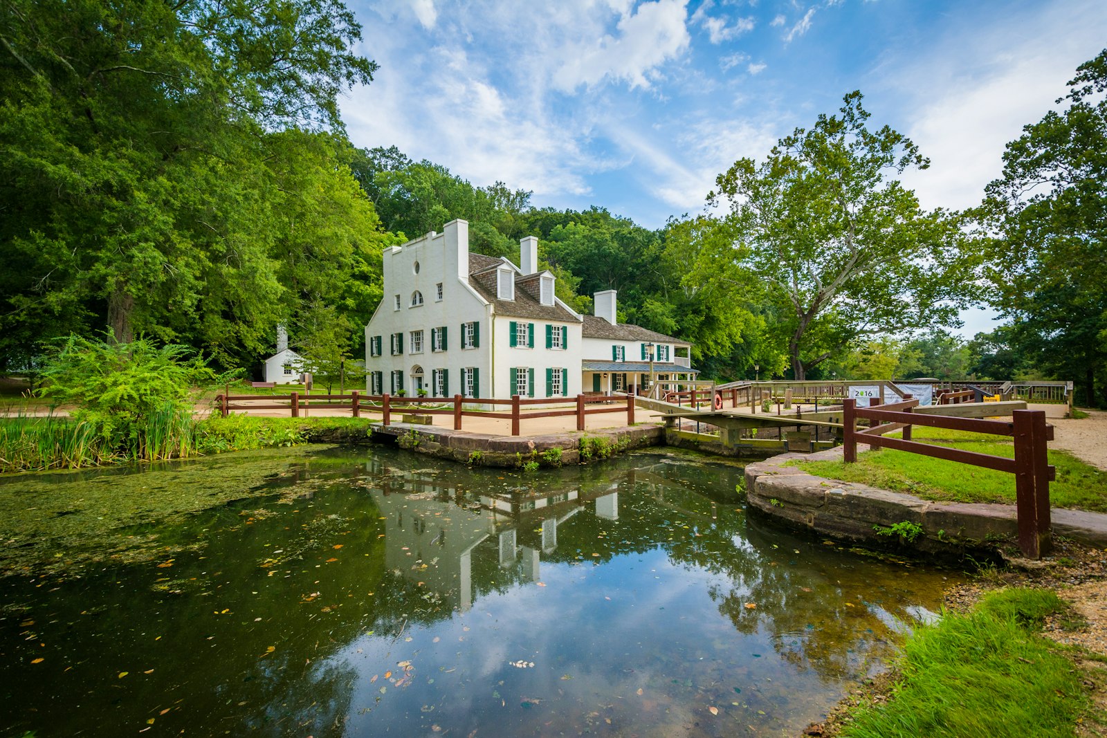 Along a steady canal, a two story structure painted white