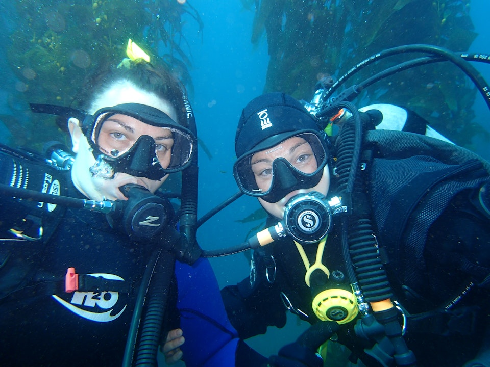 Two people wearing scuba gear on a dive underwater