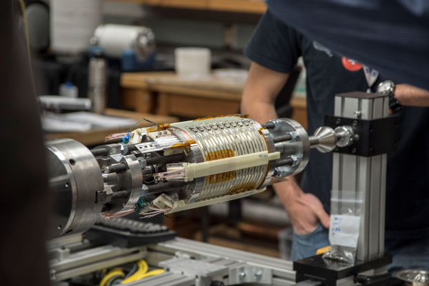 A superconducting coil with a person standing in the background