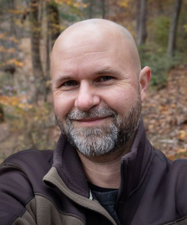 portrait of man with a beard and wearing a brown sweater