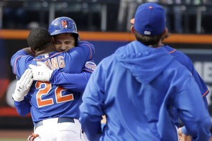 Mets catcher Travis d'Arnaud gets a hug from Eric Young after d'Arnaud's game-winning single against the Marlins.