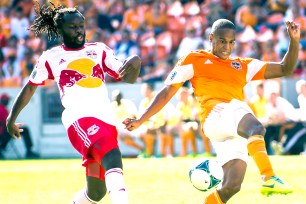 Red Bulls' Peguy Luyindula (left) battles the Dynamo's Ricardo Clark for the ball.