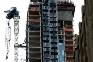 The crumpled crane hanging from a 57th Street high rise is a larger-than-life example of the plight of the neighborhood.