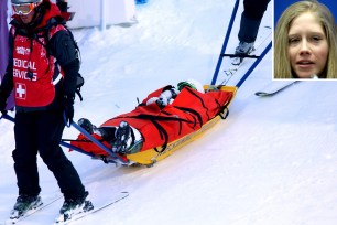 Heidi Kloser is helped off the mountain after tearing her ACL in moguls warmups.