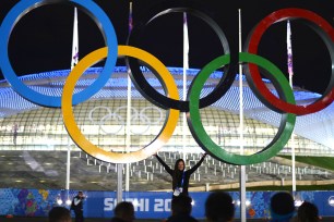 FROM RUSSIA WITH LOVE: A fan poses under Olympic rings at Sochi Olympic Park Thursday.