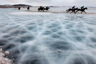 Riders compete on the frozen Yenisei River during the 44th Ice Derby amateur horse race south of the Siberian city of Krasnoyarsk.