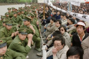 BEIJING, CHINA - APRIL 22: Several hundred of 200,000 pro-democracy student protesters face to face with policemen outside the Great Hall of the People in Tiananmen Square 22 April 1989 in Beijing as they take part in the funeral ceremony of former Chinese Communist Party leader and liberal reformer Hu Yaobang during an unauthorized demonstration to mourn his death. Hu Yaobang's death in April trigged an unprecedented wave of pro-democracy demonstrations. The April-June 1989 movement was crushed by Chinese troops in June when army tanks rolled into Tiananmen Square 04 June. (Photo credit should read CATHERINE HENRIETTE/AFP/Getty Images)