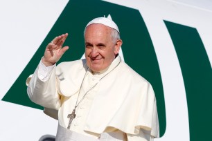 Pope Francis waves to reporters as he boards a plane to Amman, Jordan, for a three-day trip to the Middle East