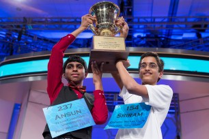 Ansun Sujoe, 13, of Fort Worth, TX (left) and Sriram Hathwar, 14, of Painted Post, NY, raise the championship trophy after being named co-champions of the National Spelling Bee on May 29.