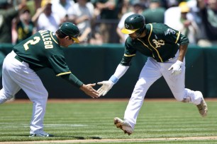 Coco Crisp gets some well-deserved skin from third base coach Mike Gallego after a three-run shot in the second inning on Sunday.