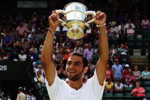 Noah Rubin celebrates with the winners trophy after winning the Boys' Singles Final match against Stefan Kozlov on day thirteen of the Wimbledon Lawn Tennis Championships at the All England Lawn Tennis and Croquet Club on July 6.