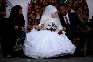 A Palestinian couple speaks with each other during their wedding ceremony at a United Nations-run school sheltering displaced Palestinians from the Israeli offensive, in Shati refugee camp in Gaza City August 13, 2014. The threat of renewed war in Gaza loomed on Wednesday as the clock ticked toward the end of a three-day ceasefire with no sign of a breakthrough in indirect talks in Cairo between Israel and the Palestinians. REUTERS/Mohammed Salem (GAZA - Tags: POLITICS SOCIETY)