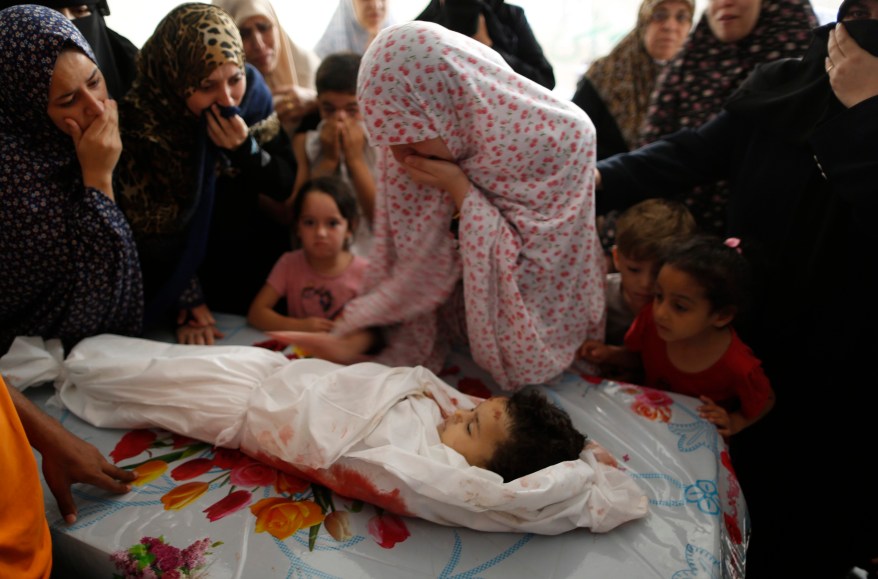 ATTENTION EDITORS - VISUAL COVERAGE OF SCENES OF INJURY OR DEATH The mother (C) of Palestinian girl Nour Abu Hasera, whom medics said was killed in an Israeli air strike, mourns next to her body during her funeral in Gaza City August 20, 2014. Israeli air strikes killed 11 Palestinians in Gaza, including the wife and infant son of Hamas's military leader, Mohammed Deif, in what the group said on Wednesday was an attempt to assassinate him after a ceasefire collapsed. Israel's military said it had carried out 60 air strikes on the Gaza Strip since hostilities resumed on Tuesday, and that Palestinians launched more than 80 rocket salvoes, some intercepted by the Israeli anti-missile Iron Dome system. REUTERS/Suhaib Salem (GAZA - Tags: POLITICS CIVIL UNREST TPX IMAGES OF THE DAY) TEMPLATE OUT