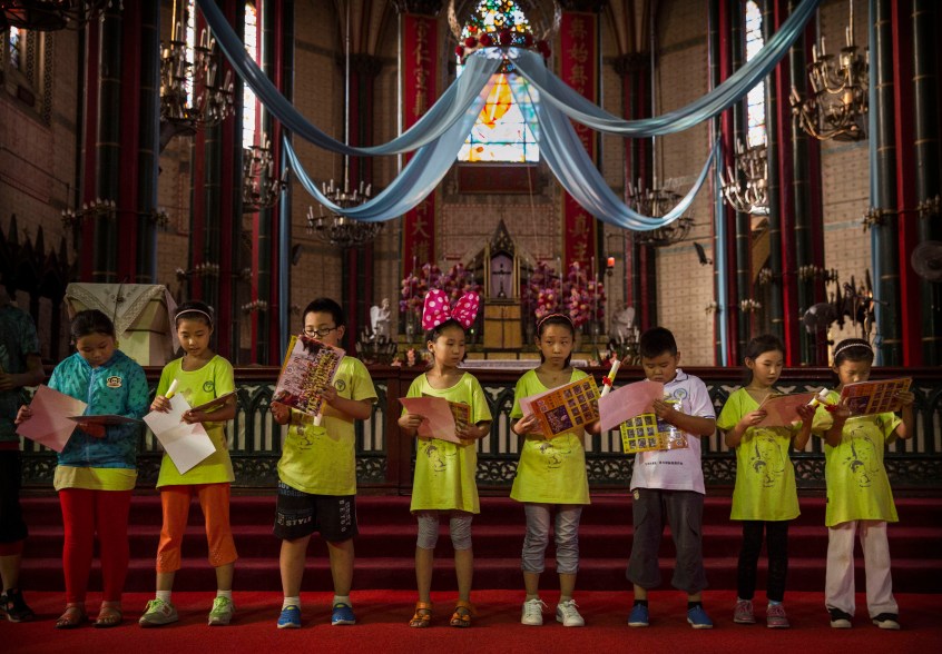 BEIJING, CHINA - AUGUST 14: Young Chinese Catholics receive certificates during a gathering as part of a summer camp at the government sanctioned Xishiku Catholic Church on August 14, 2014 in Beijing, China. In his first visit to Asia, Pope Francis sent a rare message of goodwill to China's President Xi Jinpeng today before landing in Seoul, South Korea. There have been no official relations between China and the Vatican since 1949. The Catholic Church in China is split into two avenues of worship: a state sanctioned Church known as the Patriotic Association that answers to the Communist Party, and underground Churches where worshippers are loyal to the Pope in Rome. (Photo by Kevin Frayer/Getty Images)