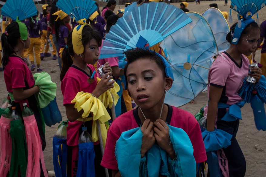 TANAUAN, LEYTE, PHILIPPINES - AUGUST 14: A students takes a break after performing during the Tanauan Fiesta, Pasaka Parade on August 14, 2014 in Tanauan, Leyte, Philippines. Residents of Tacloban city and the surrounding areas continue to focus on rebuilding their lives nine months after Typhoon Haiyan struck the coast on November 8, 2013, leaving more than 6000 dead and many more homeless. With many businesses and government operations back up and running and with the recent start of the years typhoon season, permanent housing continues to be the main focus with many families still living in temporary accommodation. As well as continuing recovery efforts Leyte is preparing for the arrival of Pope Francis, who will visit the region from January 15- 19. (Photo by Chris McGrath/Getty Images)