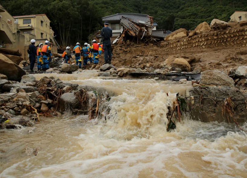 HIROSHIMA, JAPAN - AUGUST 20: Members of police continue the search for missing people among the debris of houses destroyed by a landslide caused by torrential rain at the site of a landslide in a residential area on August 20, 2014 in Hiroshima, Japan. At least 18 people were confirmed dead and several unaccounted people are missing after torrential rain caused flooding and landslides in the city of Hiroshima early today. (Photo by Buddhika Weerasinghe/Getty Images)