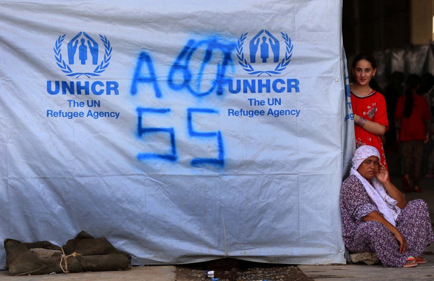 Iraqis who fled violence in the northern city of Tal Afar stand next to a tent at the Bahrka camp, 10 km west of Arbil in the autonomous Kurdistan region, on August 20, 2014. The UN refugee agency said it had launched a huge operation to bring desperately needed aid to half a million Iraqis driven from their homes by jihadist rebels. AFP PHOTO / SAFIN HAMEDSAFIN HAMED/AFP/Getty Images