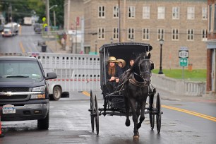 An Amish family rides along Route 812 in Heuvelton, N.Y., near where two young Amish girls were abducted.