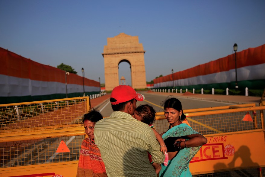 Indians stand in front of the landmark India Gate war memorial, decorated in the colors of the national flag on the eve of the countrys Independence Day in New Delhi, India, Thursday, Aug. 14, 2014. India celebrates its 1947 independence from British colonial rule on Aug. 15. (AP Photo/Bernat Armangue)