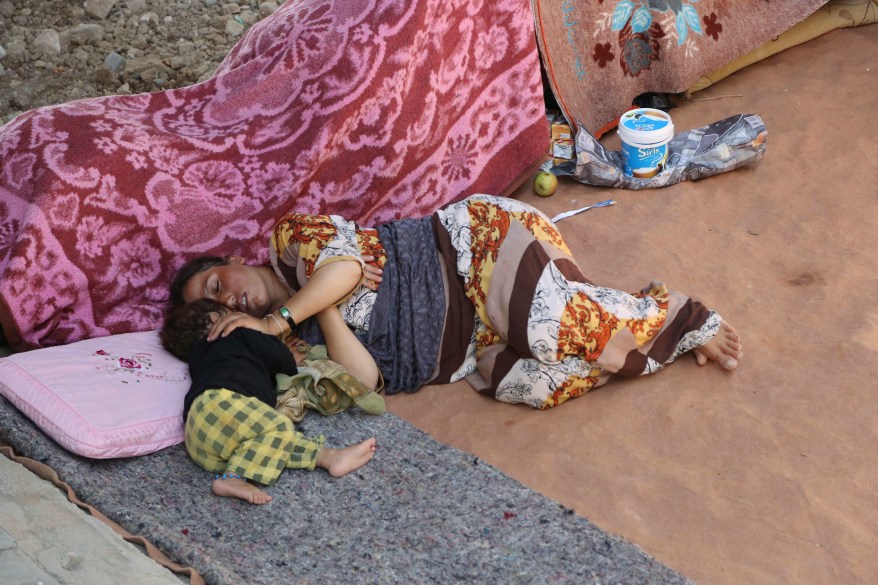 An Iraqi woman and her daughter from the Yazidi community sleep under a bridge in Dahuk, 260 miles (430 kilometers) northwest of Baghdad on Thursday, Aug. 14, 2014. The United Nations has announced its highest level of emergency for the humanitarian crisis in Iraq in the wake of the onslaught by Islamic militants who have overrun much of the country's north and west and driven out hundreds of thousands from their homes. (AP Photo/ Khalid Mohammed)