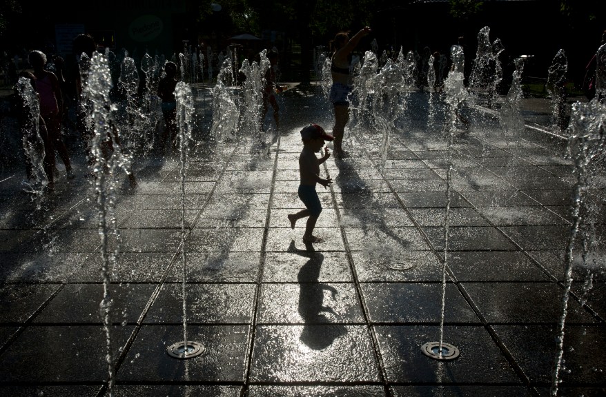 A child plays in a fountain, in Bucharest, Romania, Thursday, Aug. 14, 2014. Romania's weather authority issued a heat wave warning until the weekend with temperatures expected to exceed 37 degrees Celsius (98.6 degrees Fahrenheit) in many regions of the country.(AP Photo/Vadim Ghirda)