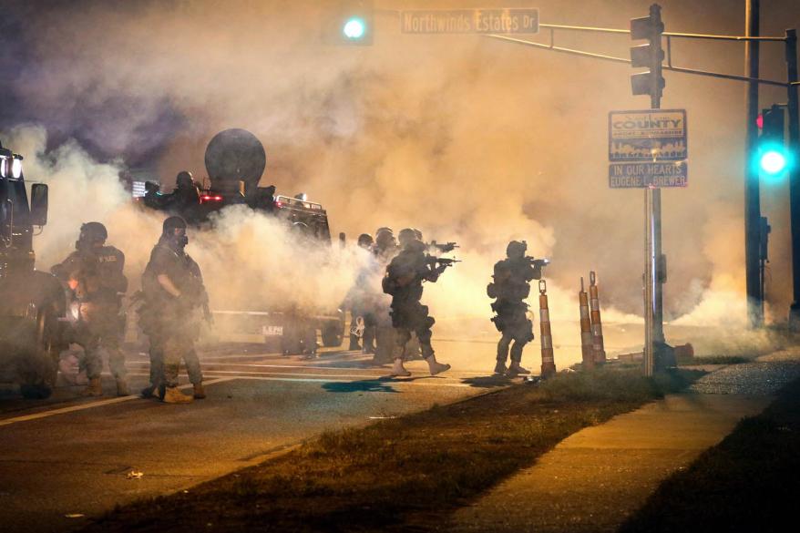 Police attempt to control demonstrators protesting the killing of teenager Michael Brown on August 18, 2014 in Ferguson.