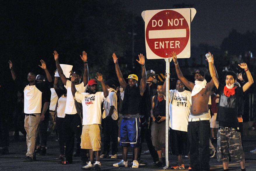 Demonstrators gesture during a protest on West Florissant Avenue in Ferguson, Missouri on August 18, 2014.
