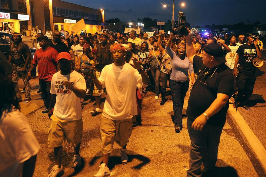 Demonstrators march during a protest on West Florissant Avenue in Ferguson, Missouri on August 18, 2014.