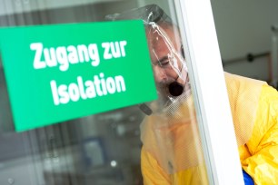 Hospital director Goetz Brodermann dons a protective suit as he enters the Isolation ward at the Schwabing Hospital, in Munich, Germany.