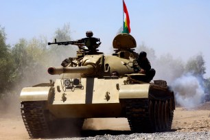 Kurdish peshmerga troops patrol in a tank during an operation against the Islamic State militants August 7th.