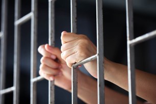 Hand on jail bars