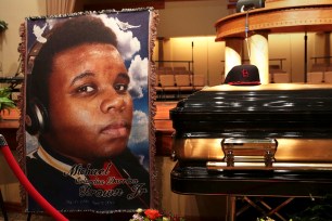 A baseball cap and a portrait of Michael Brown sit with his casket inside the Friendly Temple Missionary Baptist Church before funeral services started on Monday.