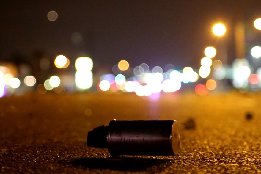 A smoke canister lies on West Florissant Road.