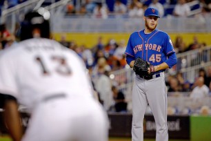 Zack Wheeler checks on runner Marcell Ozuna on third base Monday.