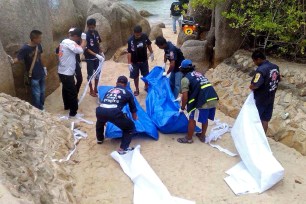 Thai workers carry the bodies of two British tourists found beaten to death on Koh Tao island on September 15.