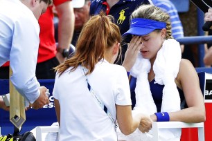 Medical staff work on Eugenie Bouchard during a timeout in her loss to Ekaternia Makarova on Monday.