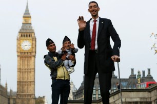 The world's shortest man Chandra Bahadur Dangi is held by nephew Dolakh Dangi as they pose with the tallest living man Sultan Kosen