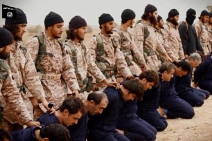 An ISIS video shows the mass murder of Syrian military personnel by beheading in a desert location.