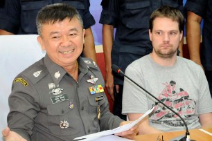 Hans Fredrik Lennart Neij (right), the founder of The Pirate Bay, is surrounded by police in the immigration office in Nong Khai, Thailand on November 4.