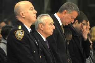 Bill de Blasio prays at St. Patrick's Cathedral with his wife Chirlane McCray, Police Commissioner Bill Bratton and Chief James O'Neill.