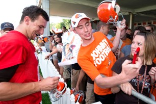 Johnny Manziel signs autographs for fans during training camp last season.