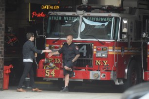 A passer-by shakes the hand of an Engine 54 firefighter.