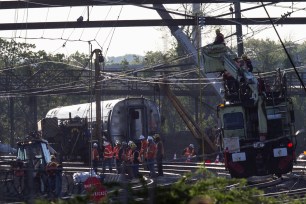 Track workers and officials work at the scene of the Amtrak derailment on Thursday.