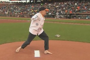 Motivational speaker Tom Wilson "throws" out the first pitch Monday night at AT&T Park in San Francisco with his right foot.